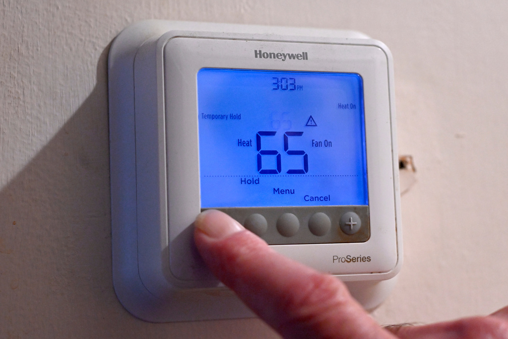Mark Bain, who is part of the Low Income Home Energy Assistance Program, sets his thermostat to 65 degrees at his home as he watches his oil levels carefully in hope that he will have enough oil to outlast the shutdown.