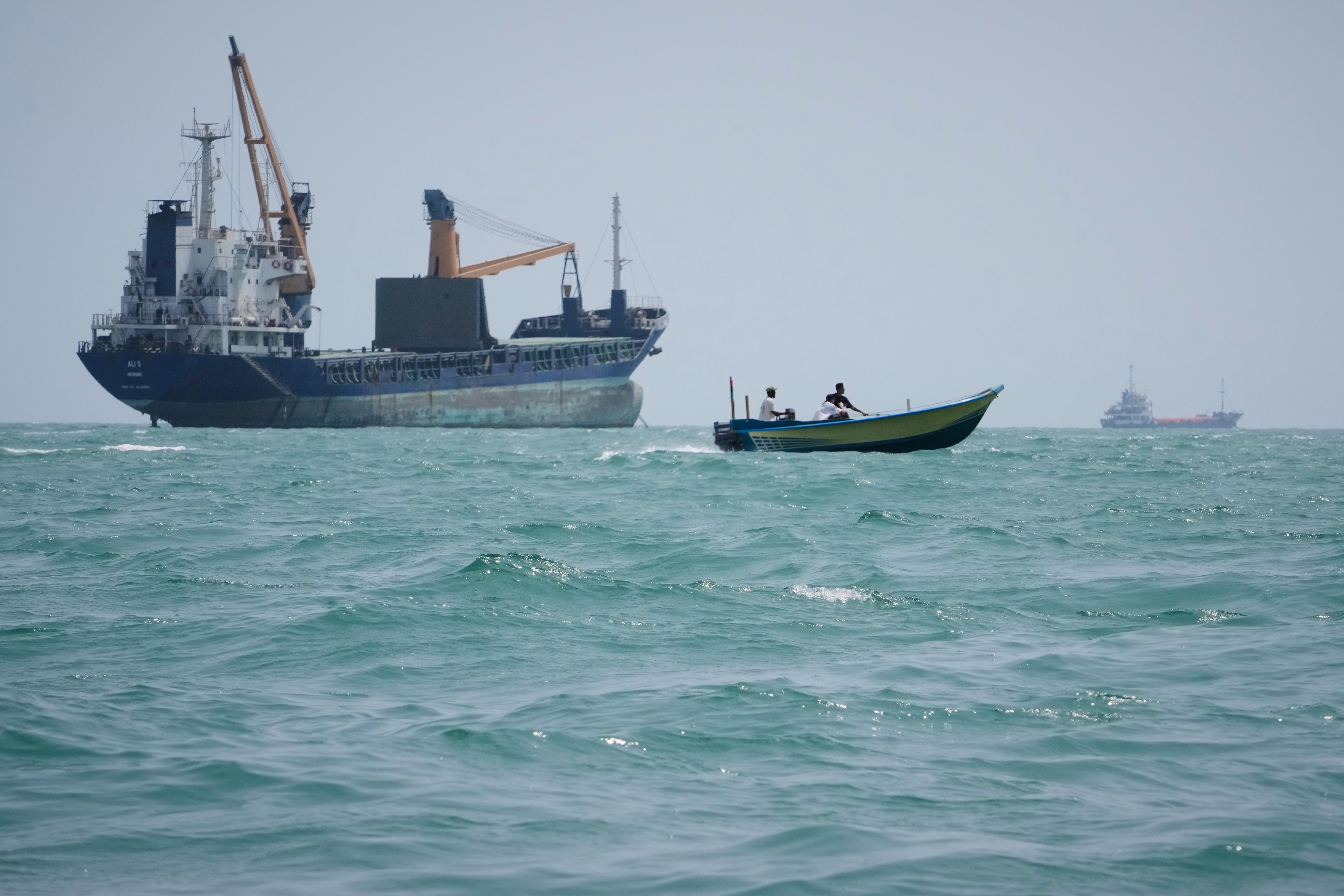 A motorboat passes a general cargo ship anchored in the Strait of Hormuz off Bandar Abbas, Iran, Sunday, Sept. 6, 2026.