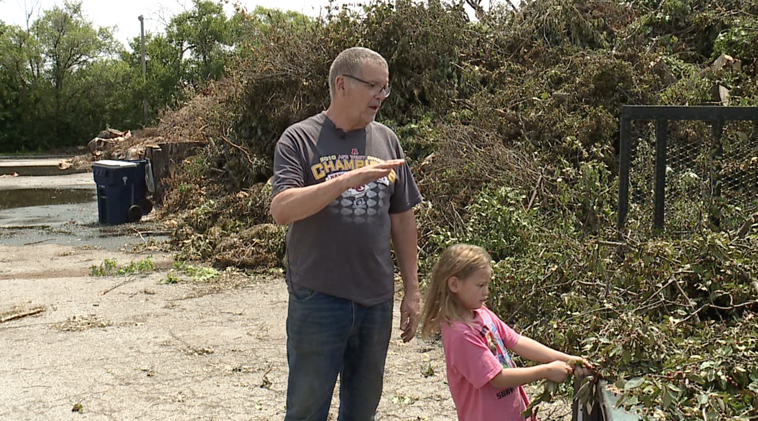 Joe Paladino and his granddaughter help neighbors clean up storm damage 