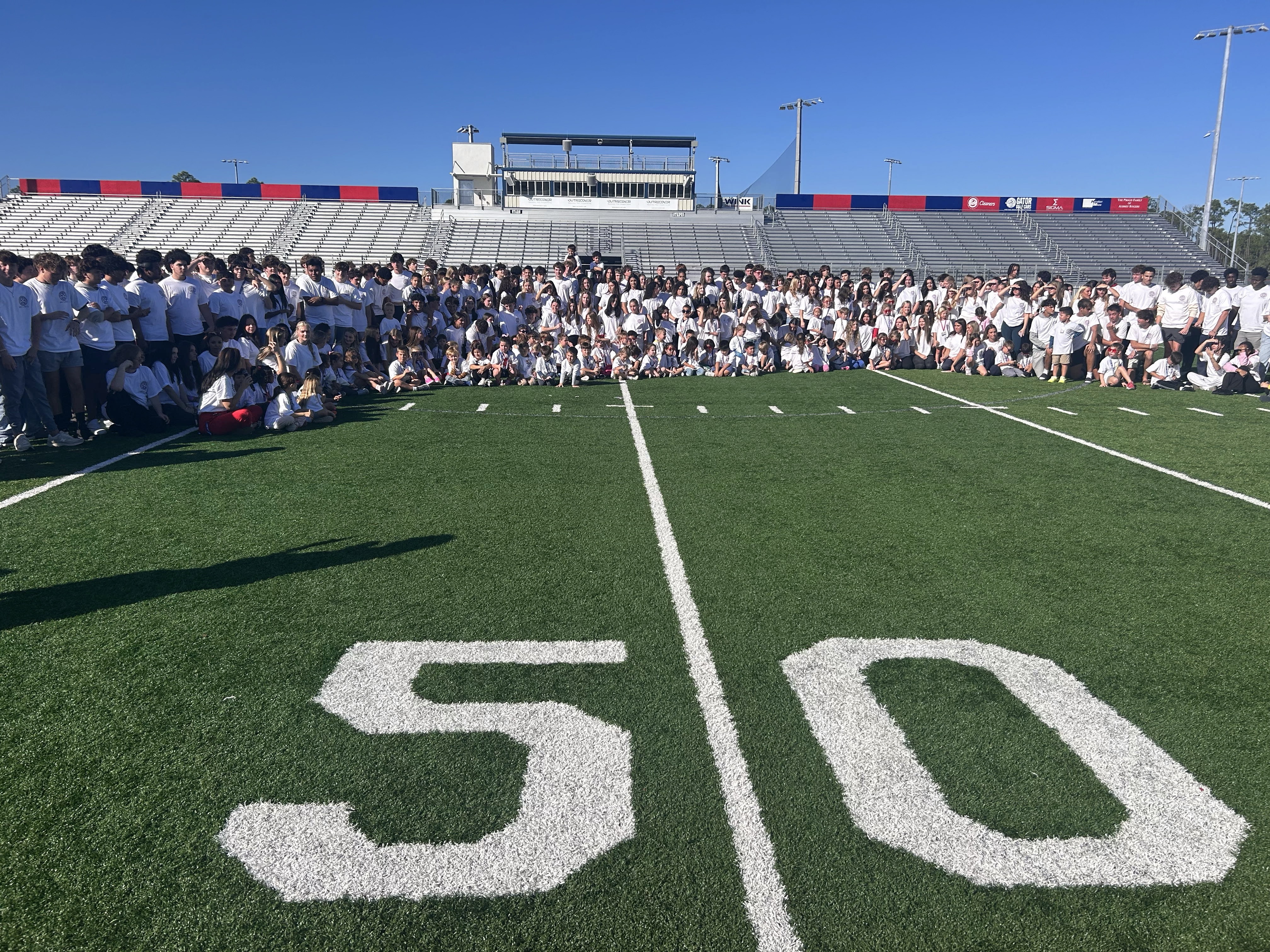 Aubrey Rogers HS seniors pose with Kindergarten students after 2nd annual lanyard pass.