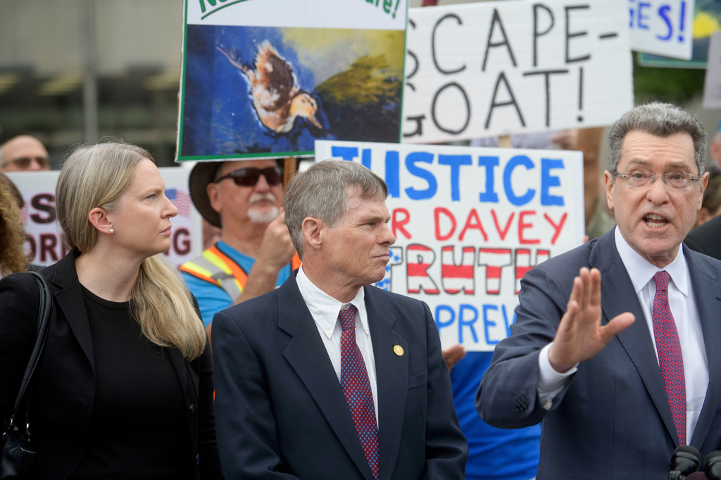 Former Olympic canoeist David Hearn, second from left, listens as his attorney Norman Eisen, right, speaks after he pleaded not guilty to allegedly damaging the Lincoln Memorial Reflecting Pool, Thursday, July 9, 2026, in Washington. 