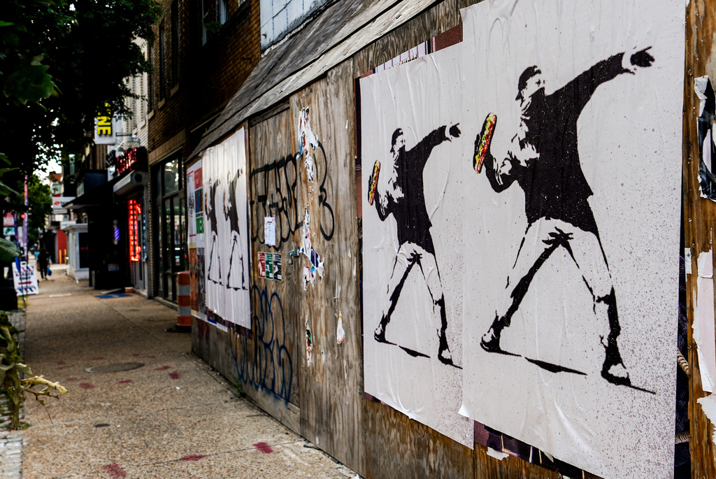 Posters of a person throwing a sandwich are pictured along H Street, Aug. 17, 2025, in Washington.
