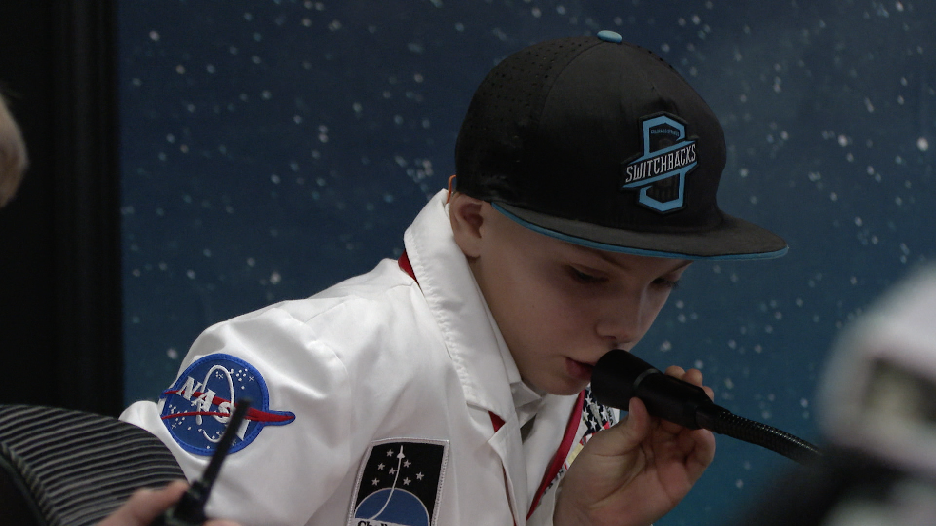 A young boy speaks into an intercomm