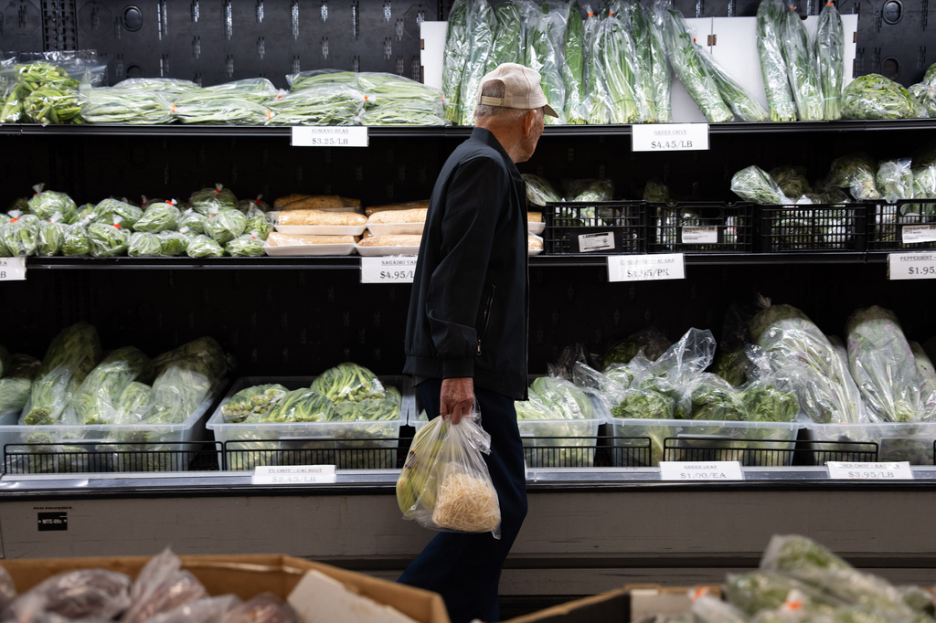A customer walks by produce at a grocery store in Portland, Ore., Wednesday, April 8, 2026. 