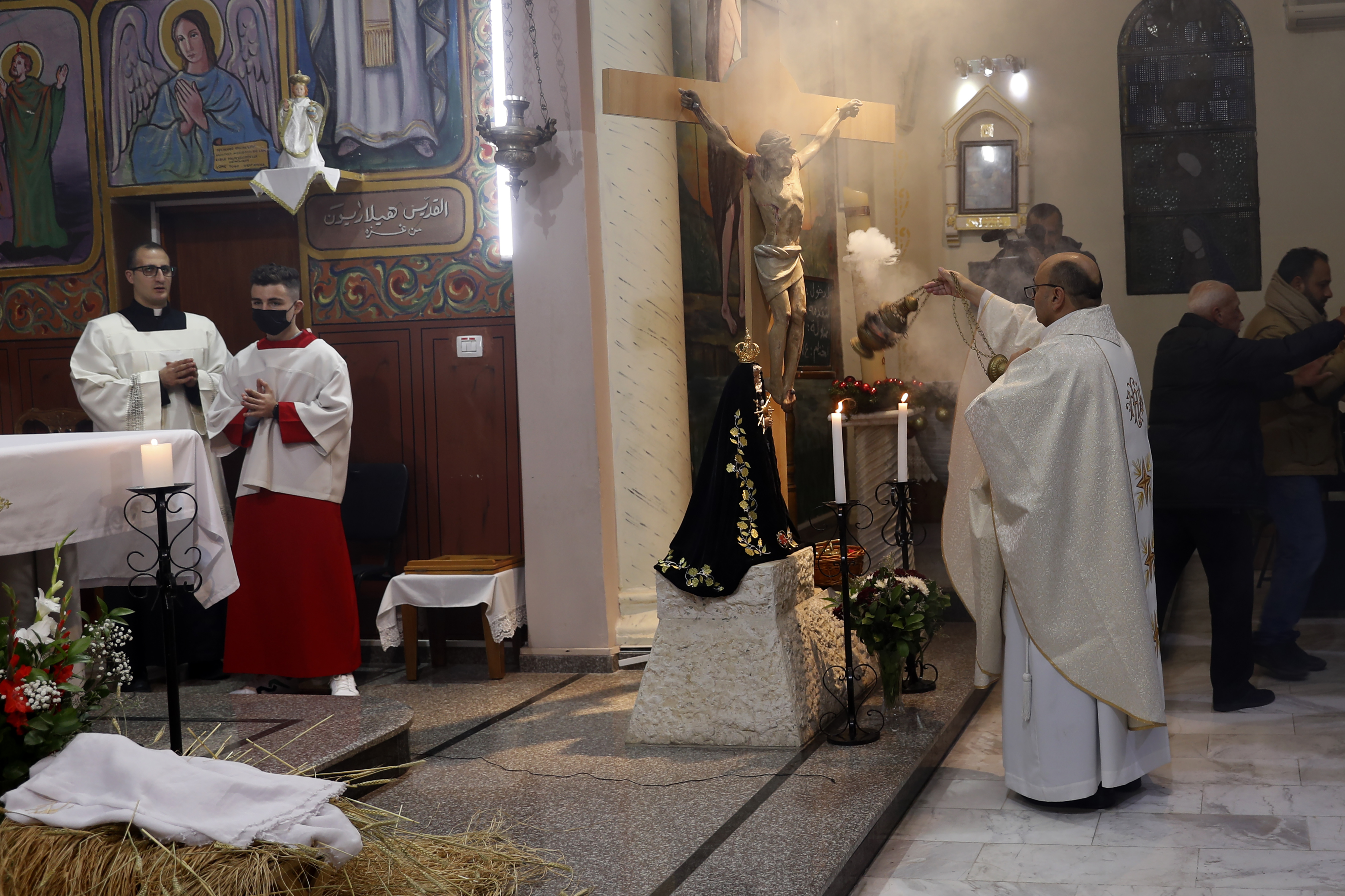 -Fr. Gabriel Romanelli, Latin parish priest of Gaza Strip, left, prays during the midnight Christmas Eve mass at Deir Al Latin Holy Family Catholic Church in Gaza City, Dec. 24, 2021. 