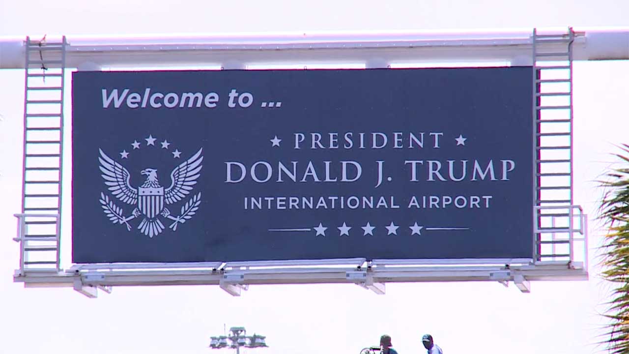 Workers at the airport entrance on July 8, 2026, installed a new sign that says "Welcome to President Donald J. Trump International Airport."
