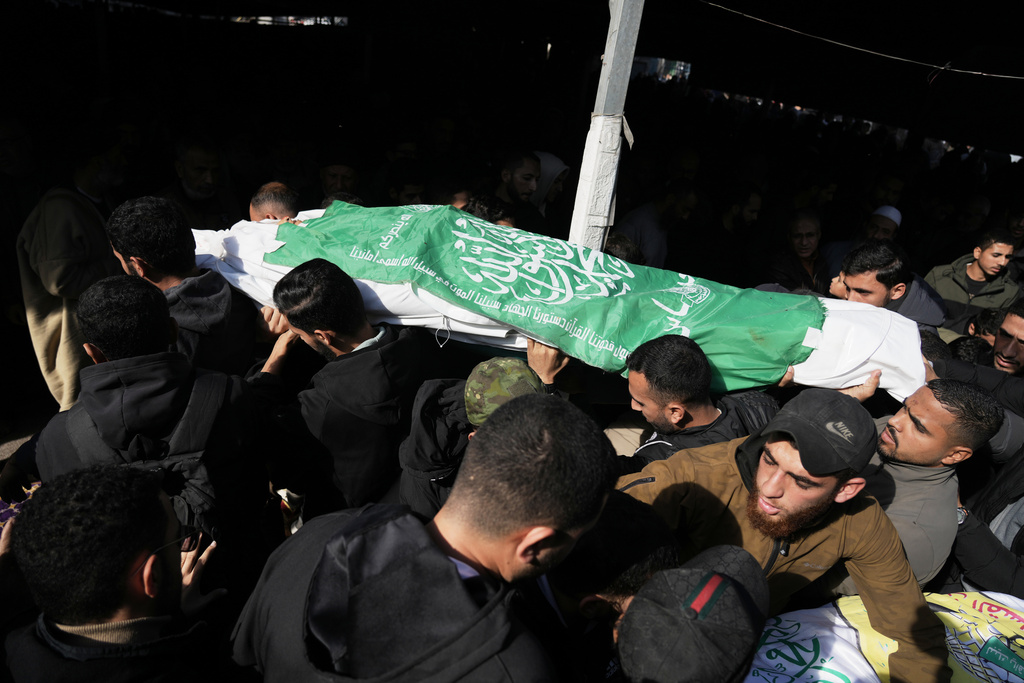 Palestinians carry the body of a Hamas militant draped in the group's flag, who was killed in an Israeli army strike, during his funeral in Gaza City.