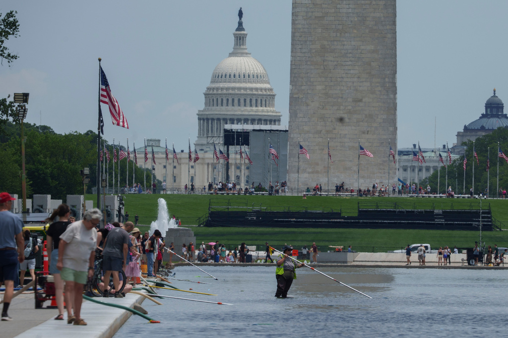 National Park Service employees work in the Lincoln Memorial Reflecting Pool Sunday, June 21, 2026, on the National Mall in Washington. 