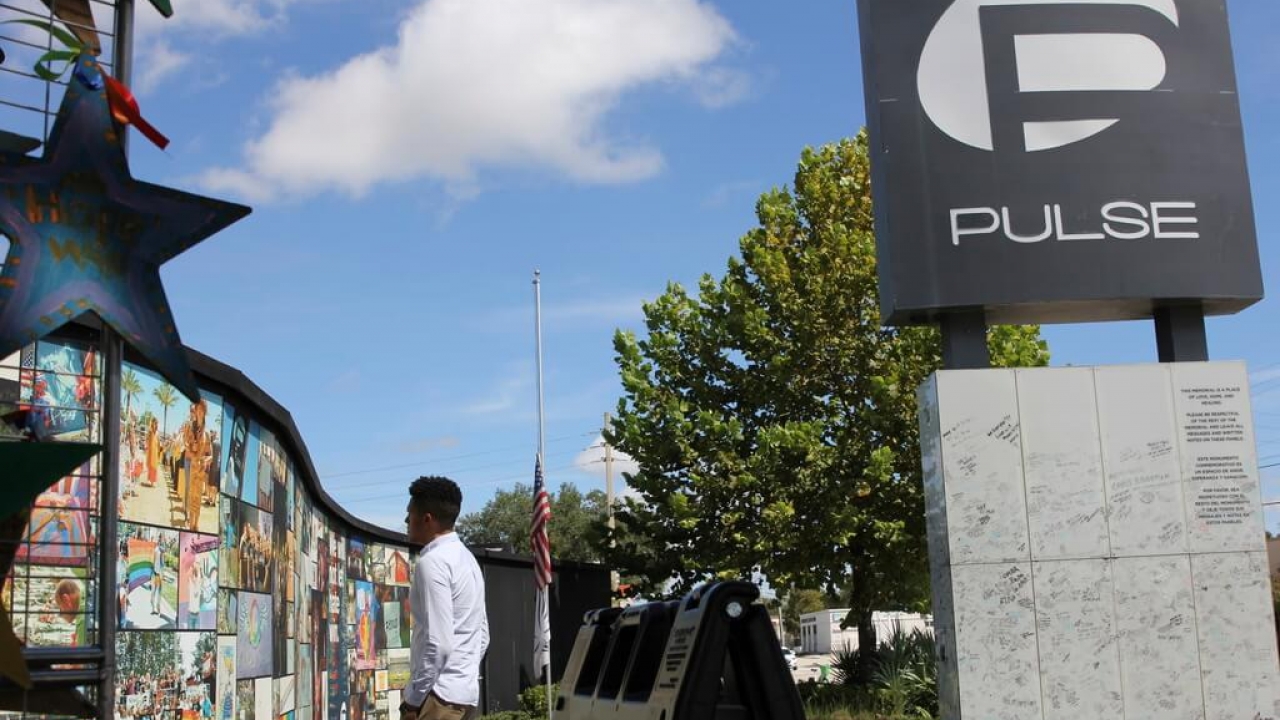 A survivor of the Pulse nightclub shooting stares at the Pulse memorial in Orlando.