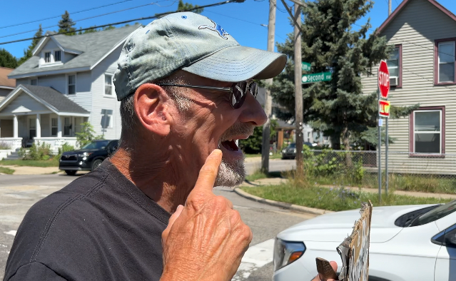 man holding sign for smiles