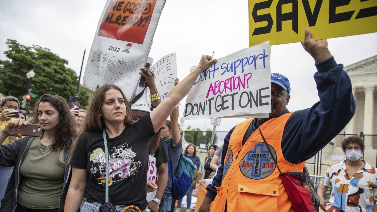 People hold signs at an abortion protest