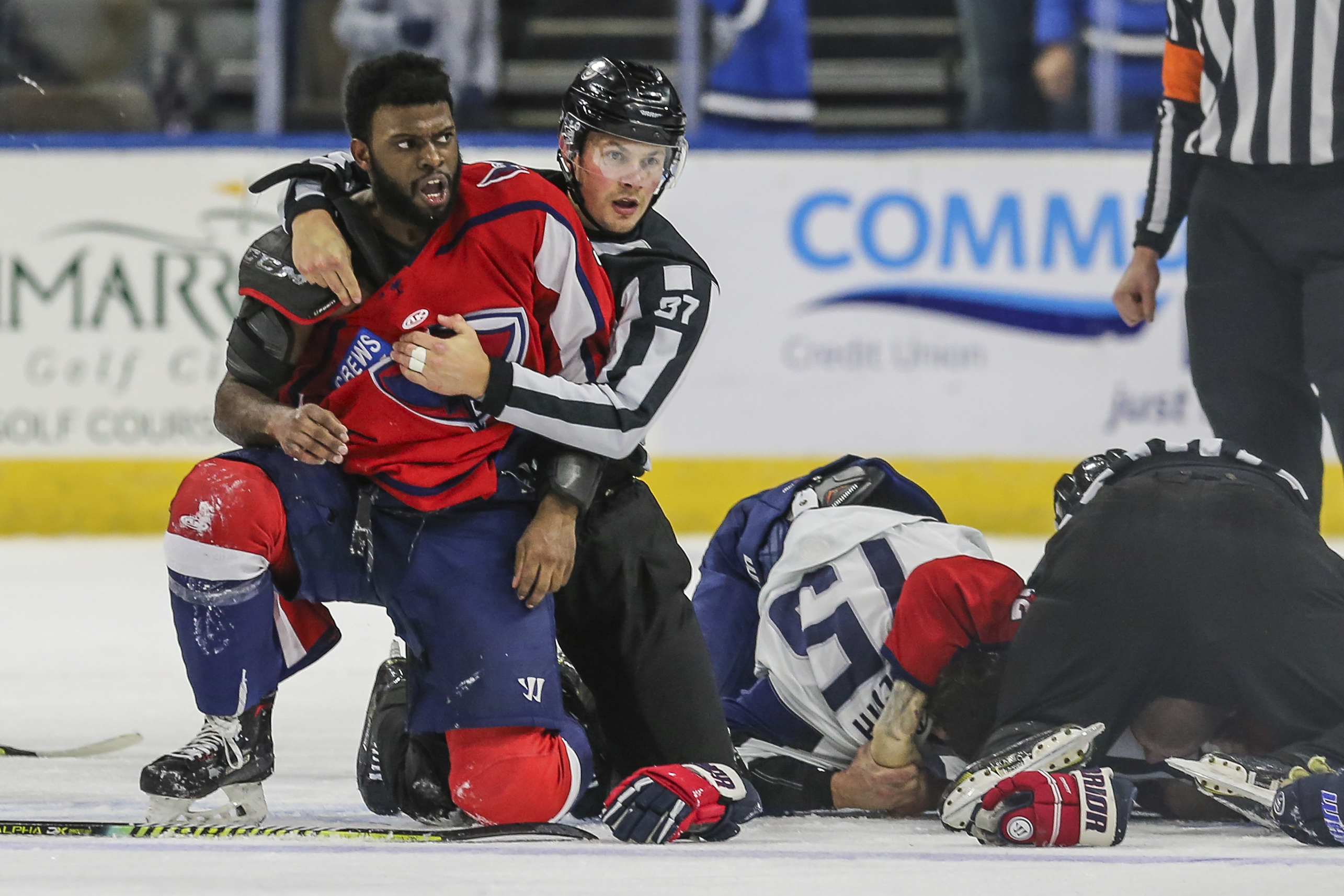 After an on-ice fight, South Carolina Stingrays defenseman Jordan Subban (5), left, is held by linesman Shane Gustafson while Jacksonville Icemen defenseman Jacob Panetta (15) is face-down on the ice engaged with another player during overtime of an ECHL hockey game in Jacksonville, Fla., Saturday, Jan. 22, 2022. The ECHL has suspended Panetta after the brother of longtime NHL defenseman P.K. Subban accused the Jacksonville defenseman of making “monkey gestures” in his direction. 