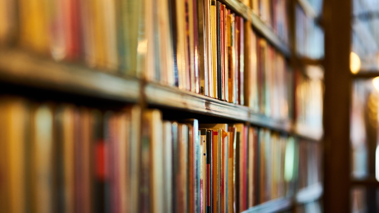 Selective focus photograph of a brown wooden bookshelf