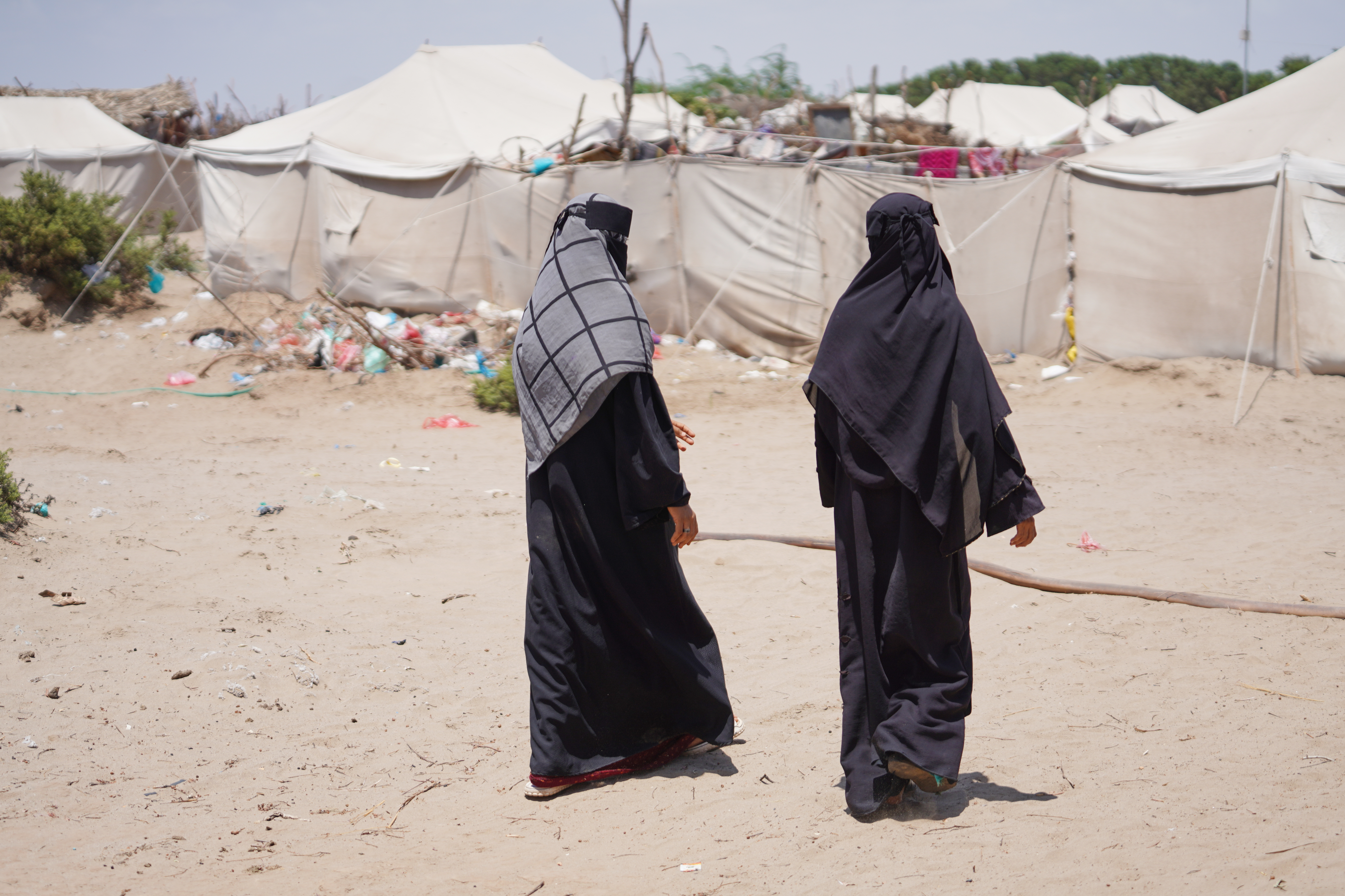Displaced Yemenis, from Al Khawkhah city, 400 kilometers (249 miles) south west of Sanaa, walk past their temporary shelter in Aden, Yemen, Sunday, Sept. 13, 2026.