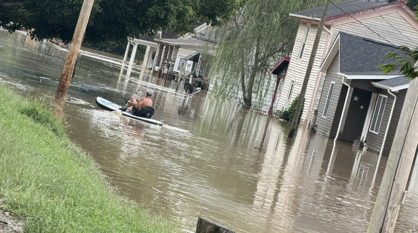 A man kayaks down Metamora Main Street during historic flooding