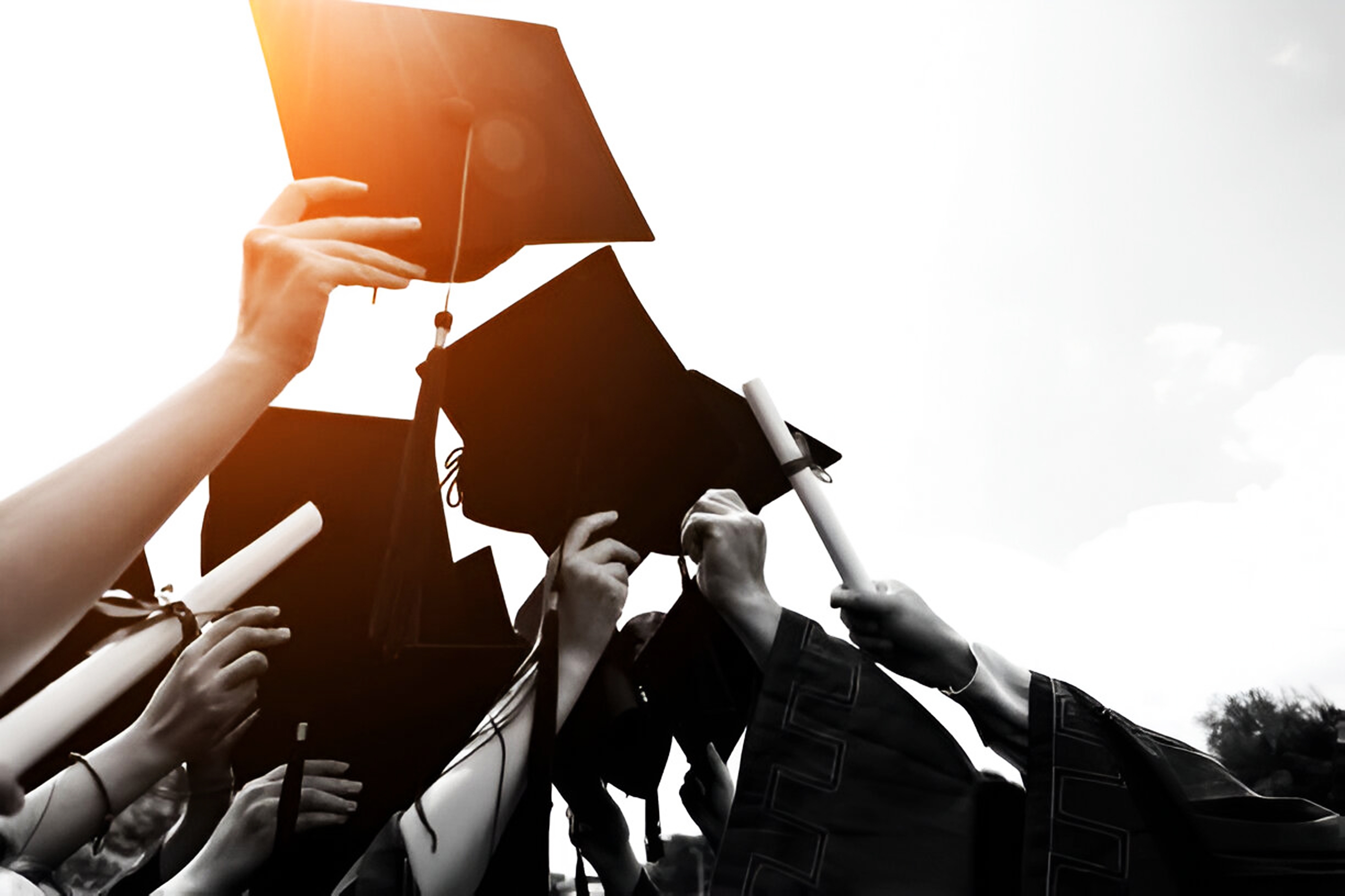 Graduates about to throw hats into the air.