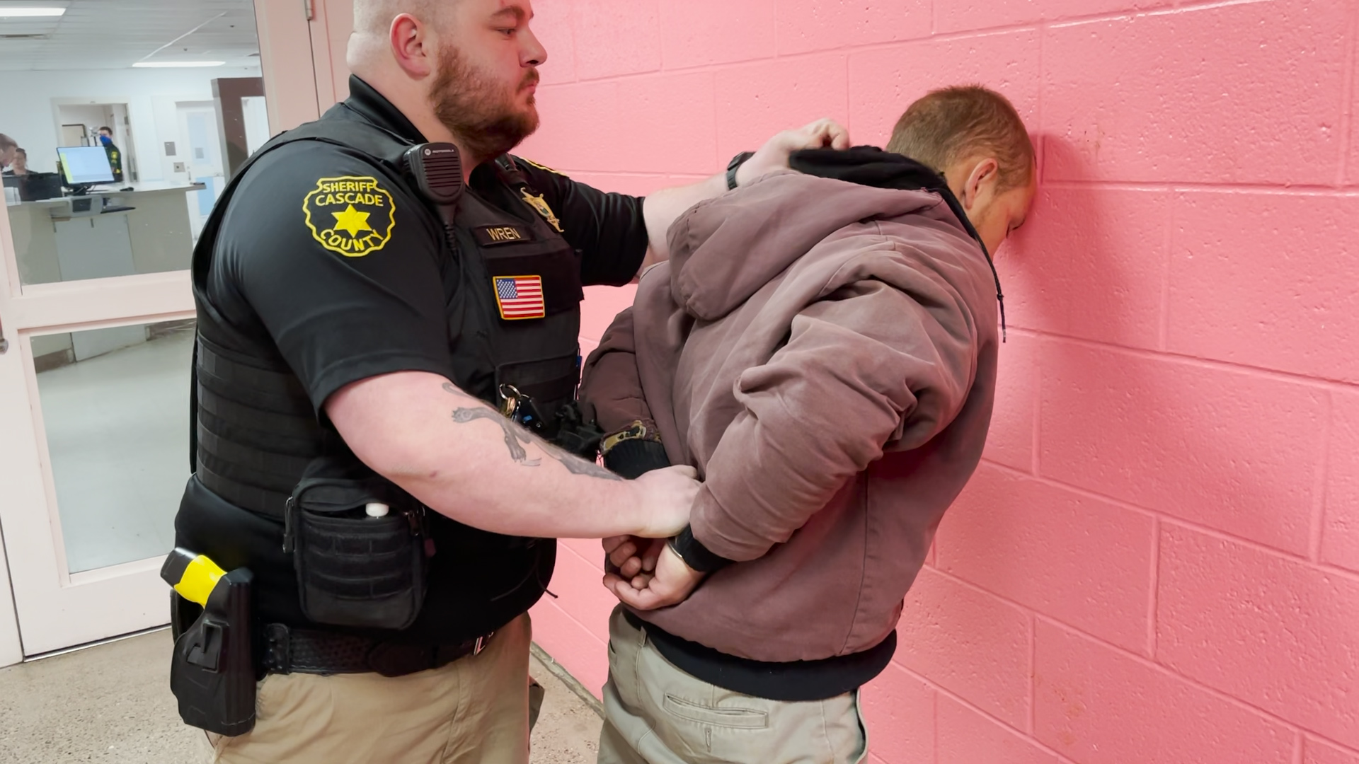 After arresting a suspect on outstanding warrants, Dep. Wren prepares to take the suspect into booking.