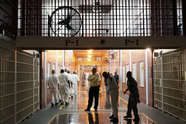 Prison staff and inmates move through the Darrington Unit's main hallway on Wednesday