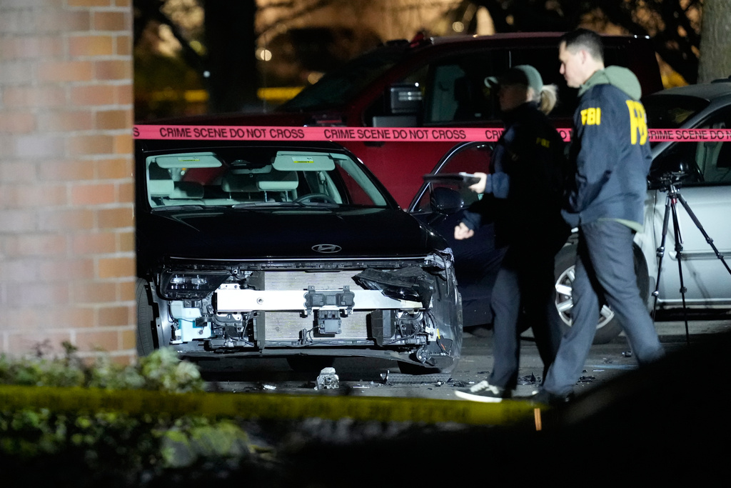 A damaged car is seen as law enforcement officials work the scene following reports that federal immigration officers shot and wounded people in Portland, Ore., Thursday, Jan. 8, 2026. 