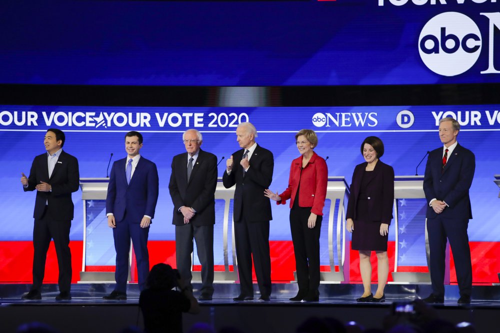 From left, Democratic presidential candidates entrepreneur Andrew Yang, former South Bend Mayor Pete Buttigieg, Sen. Bernie Sanders, I-Vt., former Vice President Joe Biden, Sen. Elizabeth Warren, D-Mass., Sen. Amy Klobuchar, D-Minn., and businessman Tom Steyer stand on stage Friday, Feb. 7, 2020, before the start of a Democratic presidential primary debate hosted by ABC News, Apple News, and WMUR-TV at Saint Anselm College in Manchester, N.H. (AP Photo/Charles Krupa)