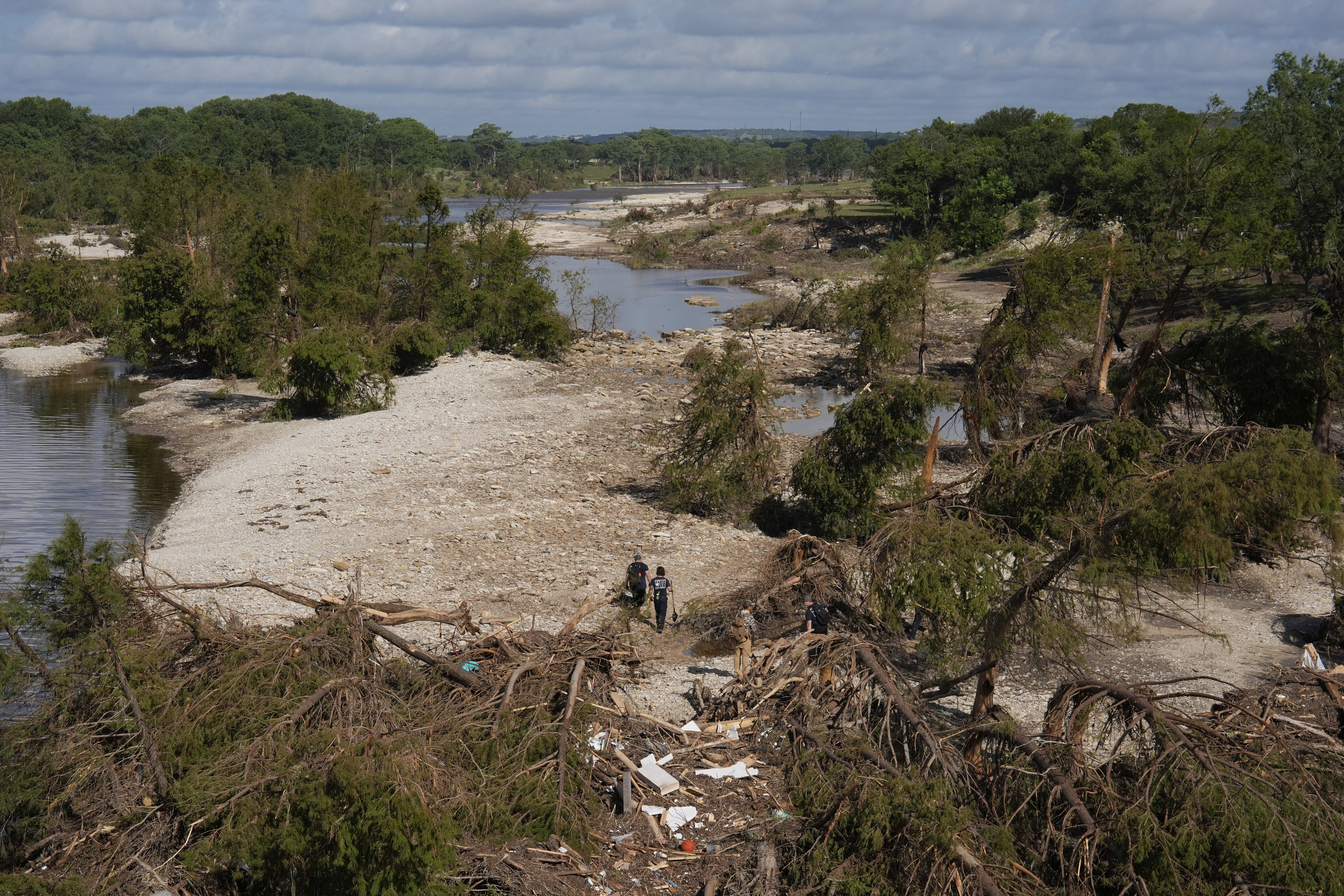 Search and rescue teams from Kerrville Fire Department walk past debris after flooding near the banks of the Guadalupe River in Kerrville, Texas, on Tuesday, July 8, 2025. 