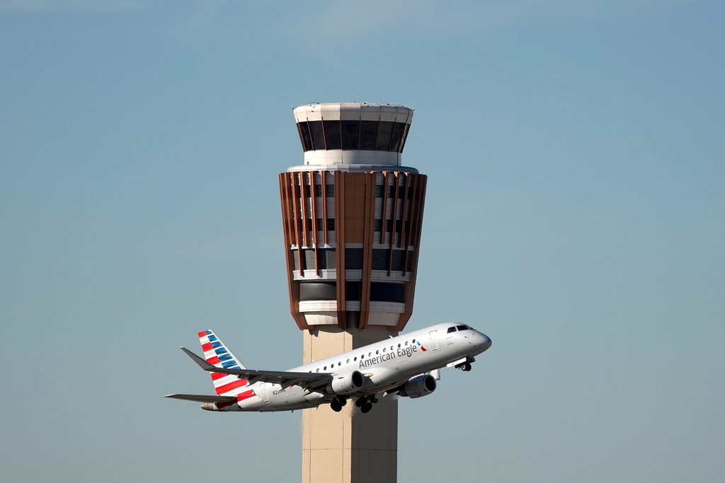 An American Airlines American Eagle jet flies past the air traffic control tower at Phoenix Sky Harbor International Airport.