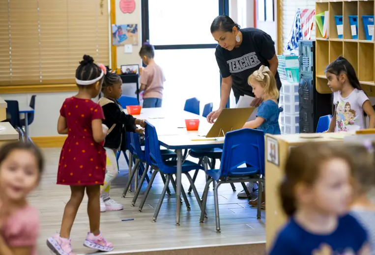 Marina Hernandez helps students clean up for center time in her Pre-K 2 classroom at Gingerbread Kids Academy in Richmond, Texas, in 2024. Children outnumber seniors in Texas, according to U.S. Census dat.