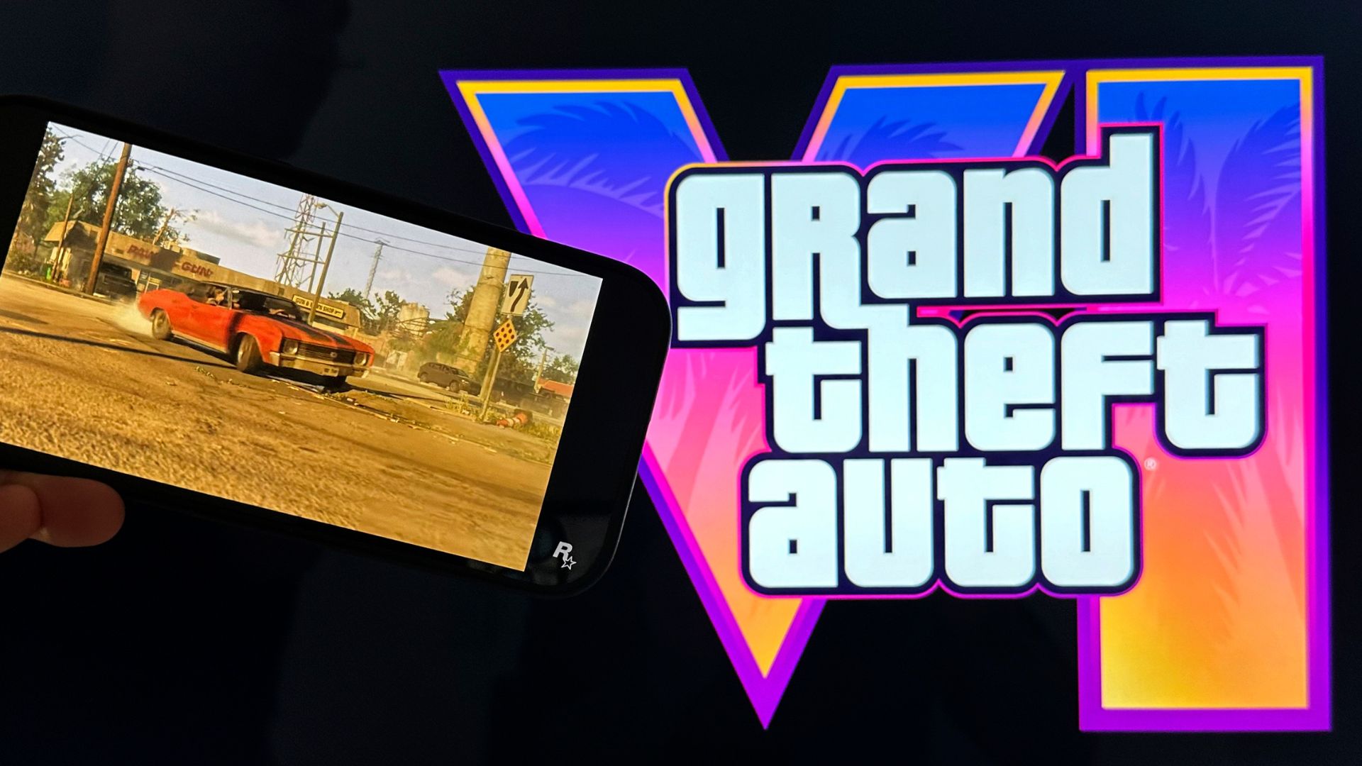 Scenes from the trailer of Grand Theft Auto VI are shown on a smartphone and monitor.