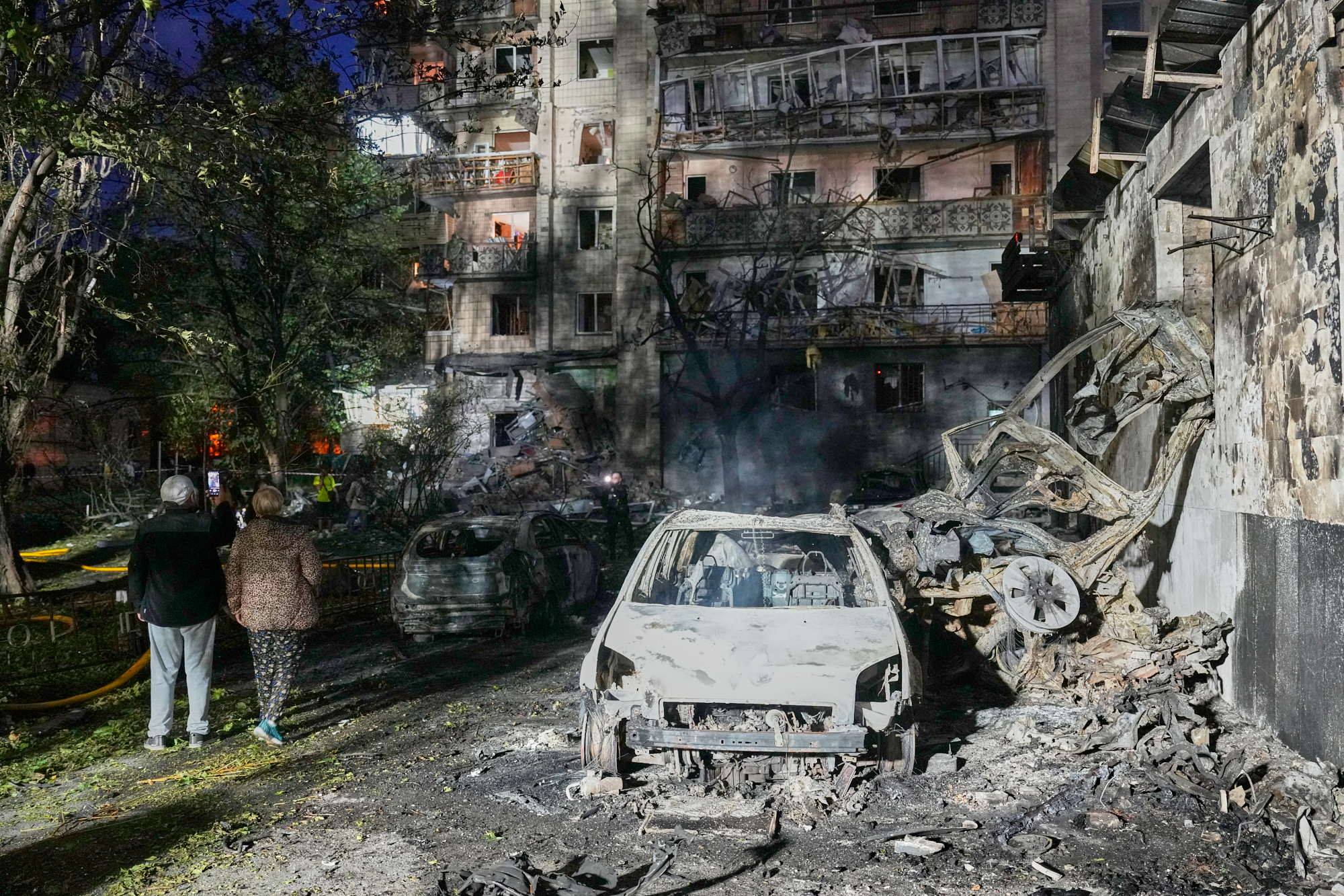 Local residents walk among debris following Russia's missile attack in Kyiv, Ukraine, Sunday, July 19, 2026.