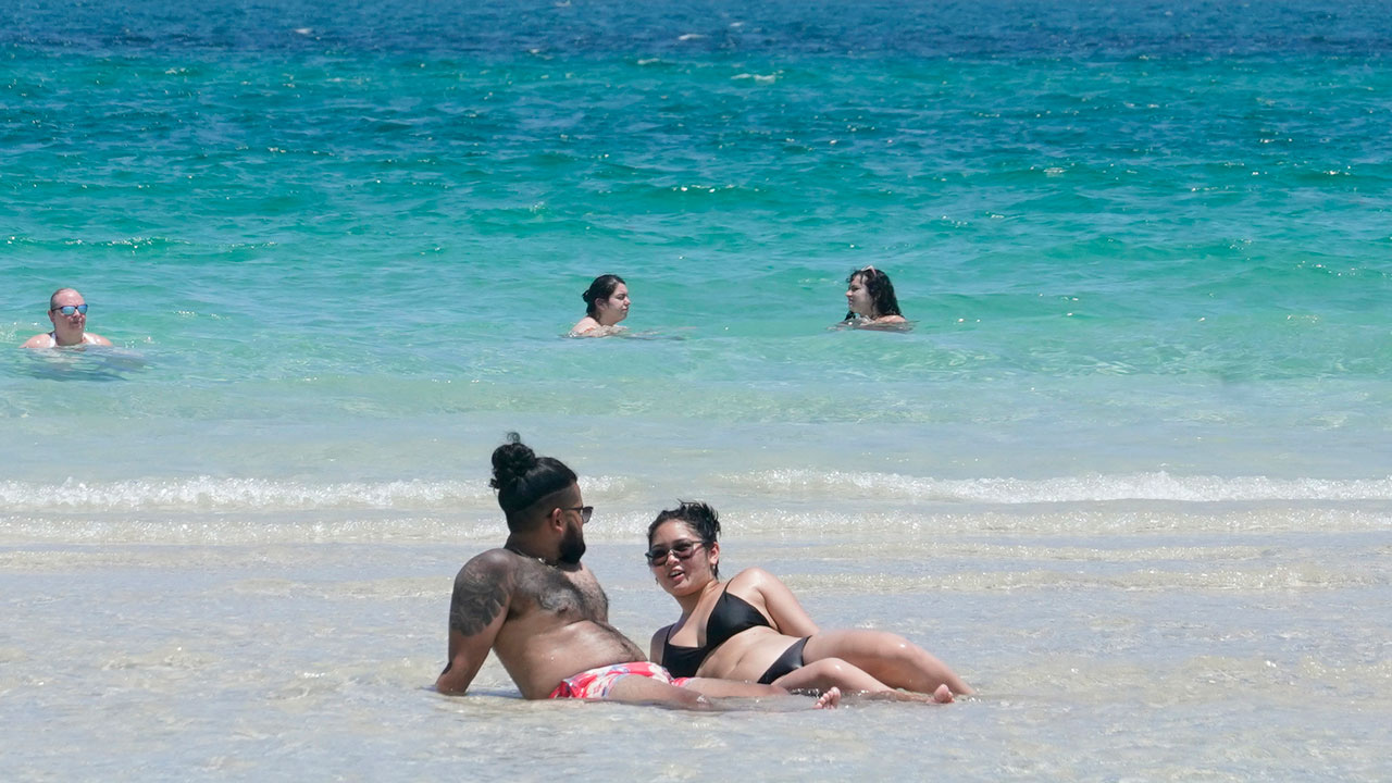 Couple sunbathes on a sand bar Wednesday, July 13, 2022, in Miami Beach, Fla. 
