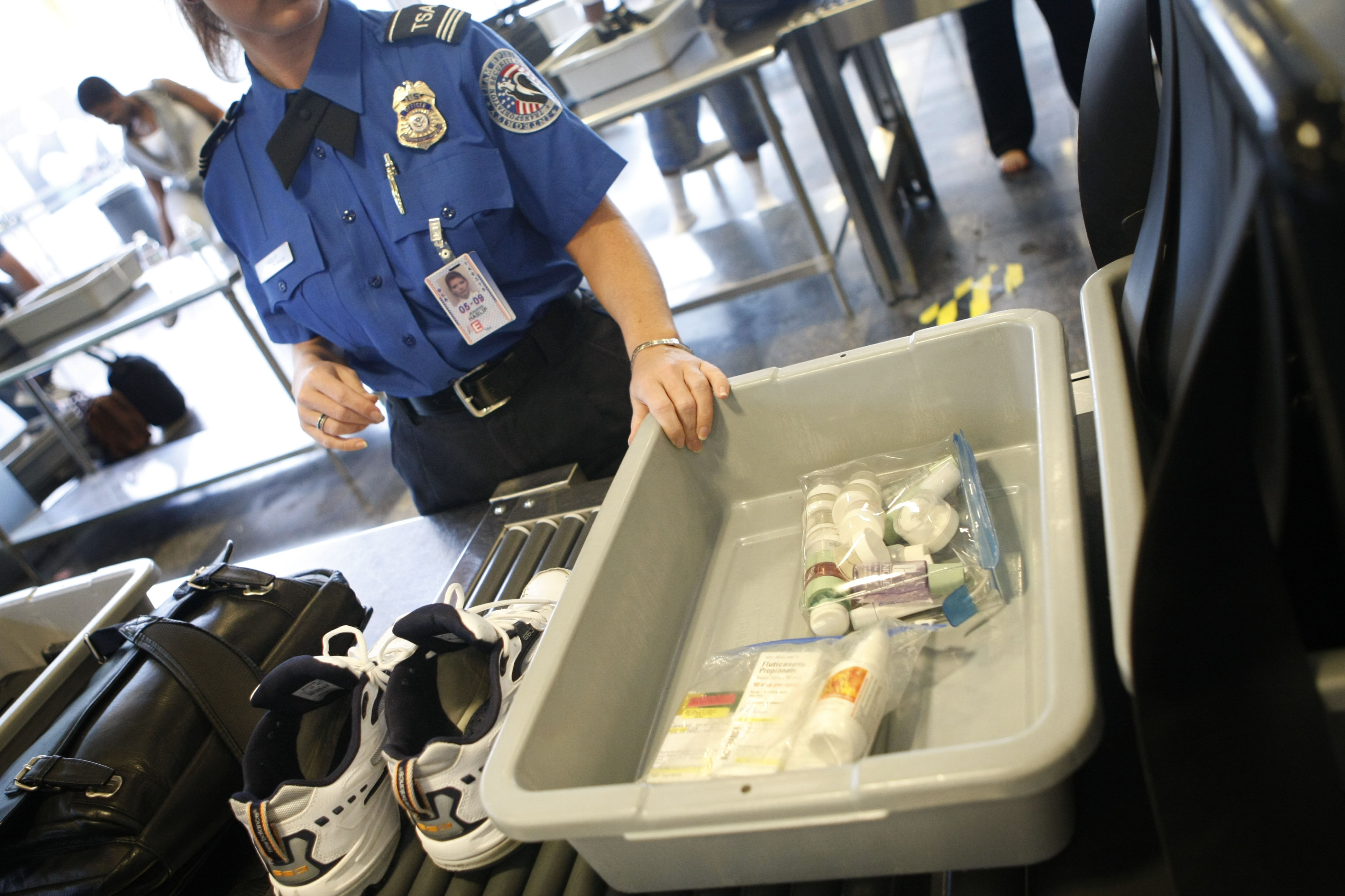 Shoes and small liquid containers are placed in bins to be screened by TSA Supervisor Jennifer Haslip at the x-ray machine at Washington's Ronald Reagan National Airport, Friday, June 27, 2008. 