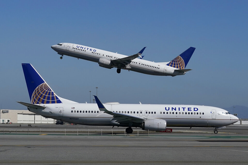 File photo shows a United Airlines airplane taking off over a plane on the runway at San Francisco International Airport.