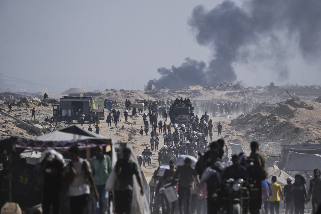 Palestinians carry sacks of flour unloaded from a humanitarian aid convoy on the outskirts of Beit Lahiya, northern Gaza Strip.