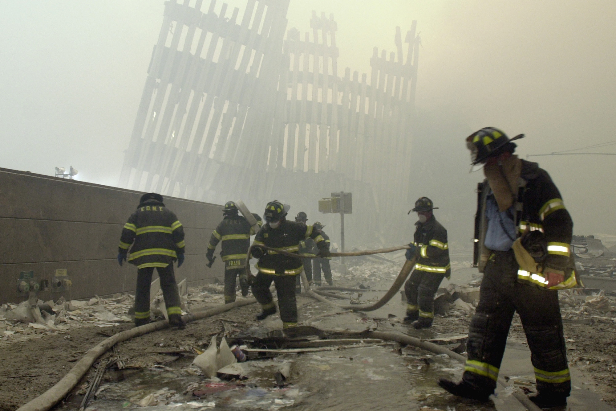  In this Sept. 11, 2001 photo, firefighters work beneath destroyed mullions, the vertical struts which once faced the outer walls of the World Trade Center towers, after a terrorist attack on the twin towers in New York. 