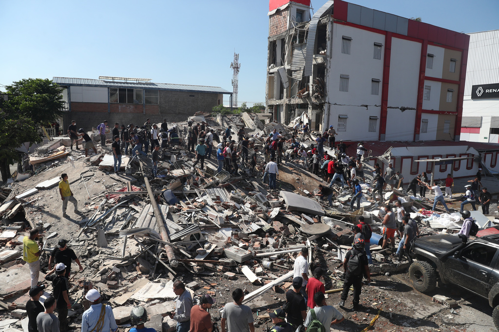 Residents and rescue workers search through the rubble of a collapsed building after an earthquake struck Cali, Colombia, Monday, Aug. 10, 2026. 