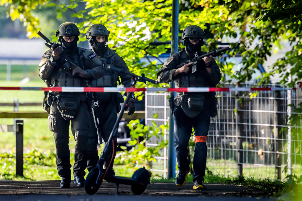 Armed police officers patrol near the Schachen horse racing track in Aarau following a shooting during a rave event near Aarau, Switzerland, Sunday, Aug. 30, 2026.