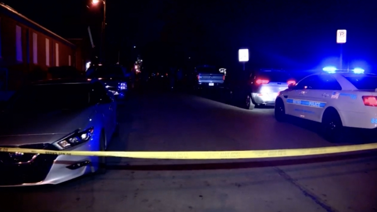 Police car with lights on parked in front of caution tape