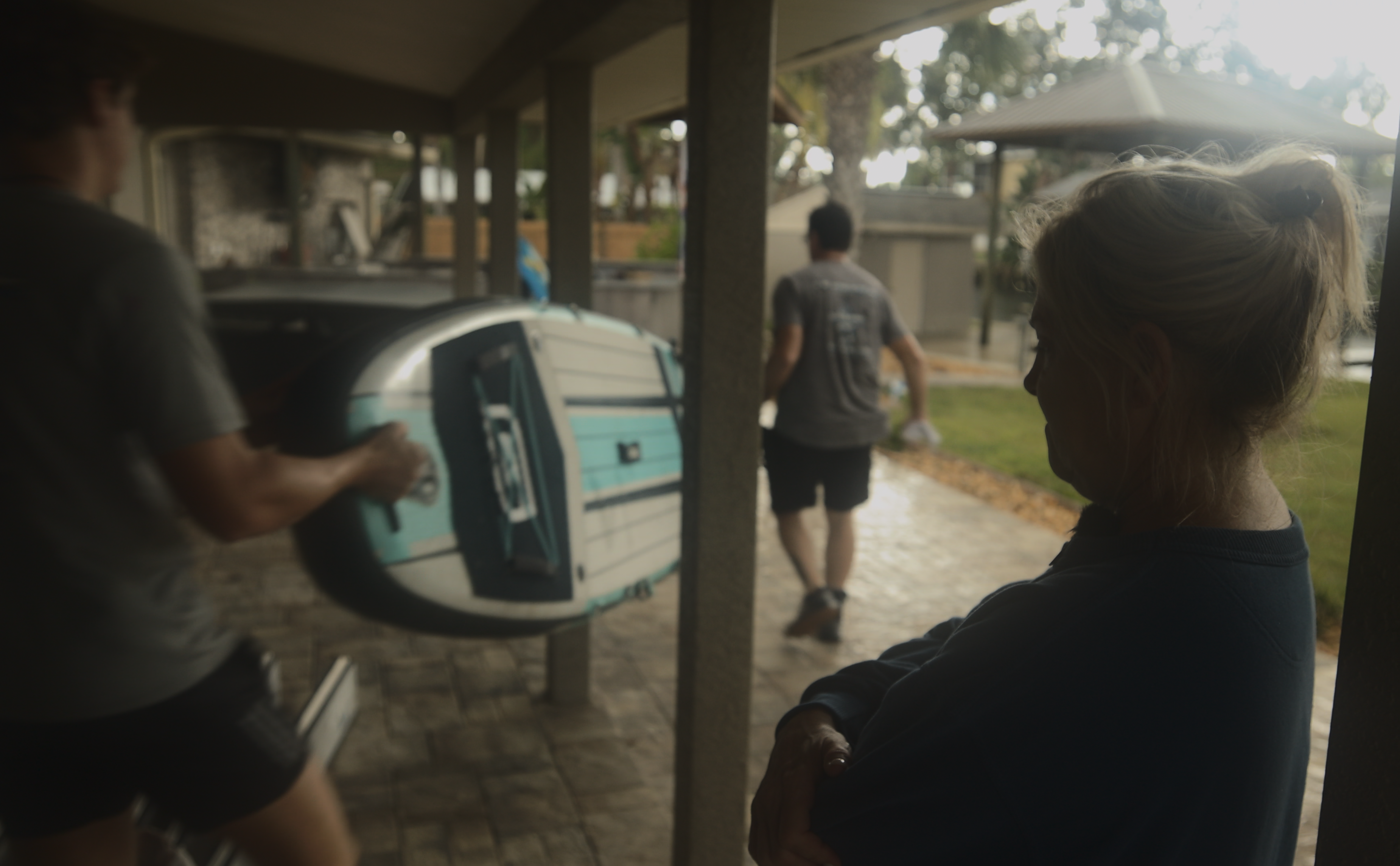 Tara Salute watches as friends take her paddle board into the backyard.