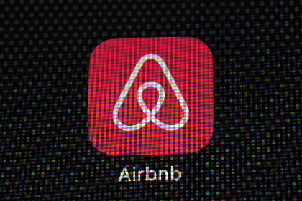 The Airbnb app icon is displayed on an iPad screen.