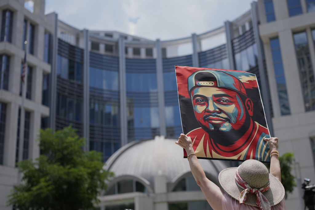 Katheryn Millwee holds a portrait of Kilmar Abrego Garcia outside the federal courthouse on June 25, 2025, in Nashville, Tenn.