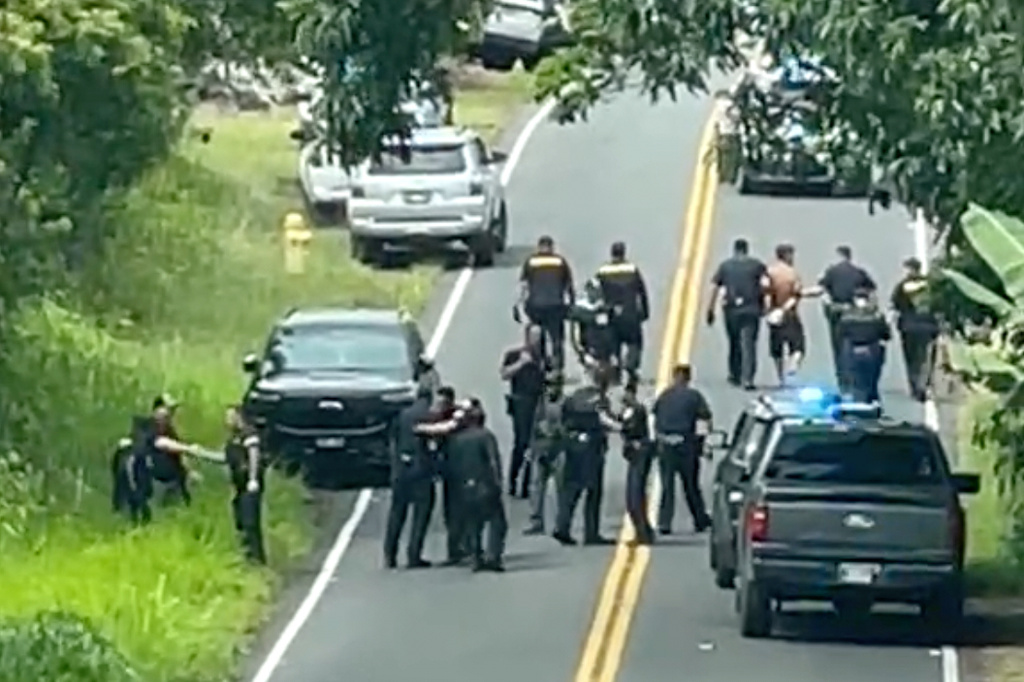 Police arrest a man accused of multiple killings, right, on Thursday, May 28, 2026, in Kaimu, Hawaii.