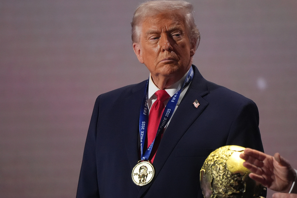 FILE - President Donald Trump stands on stage next to the FIFA World Cup after receiving the FIFA Peace Prize during the draw for the 2026 soccer World Cup at the Kennedy Center in Washington, Dec. 5, 2025. 