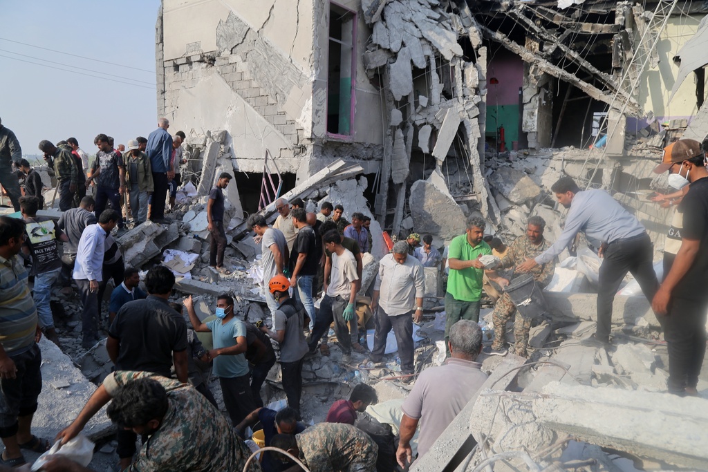 Rescue workers and residents search through the rubble in the aftermath of a strike on a girls' elementary school in Minab, Iran, Saturday, Feb. 28, 2026. 