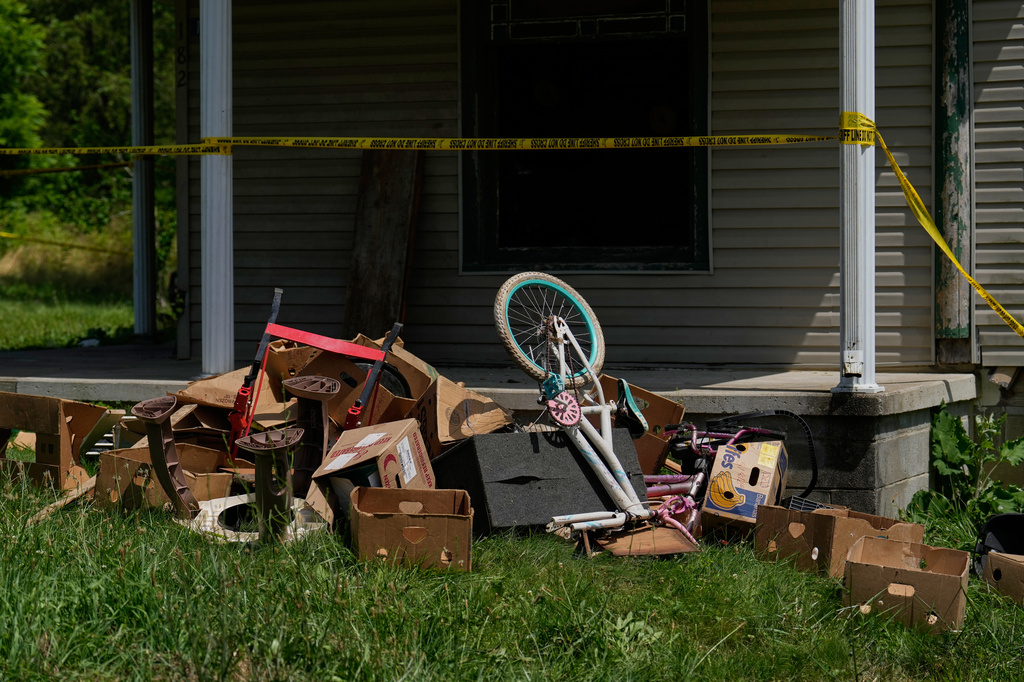 Police tape and debris are seen at a home where authorities say they removed 16 children and arrested four adults in Hamden, Ohio, Wednesday, July 1, 2026.