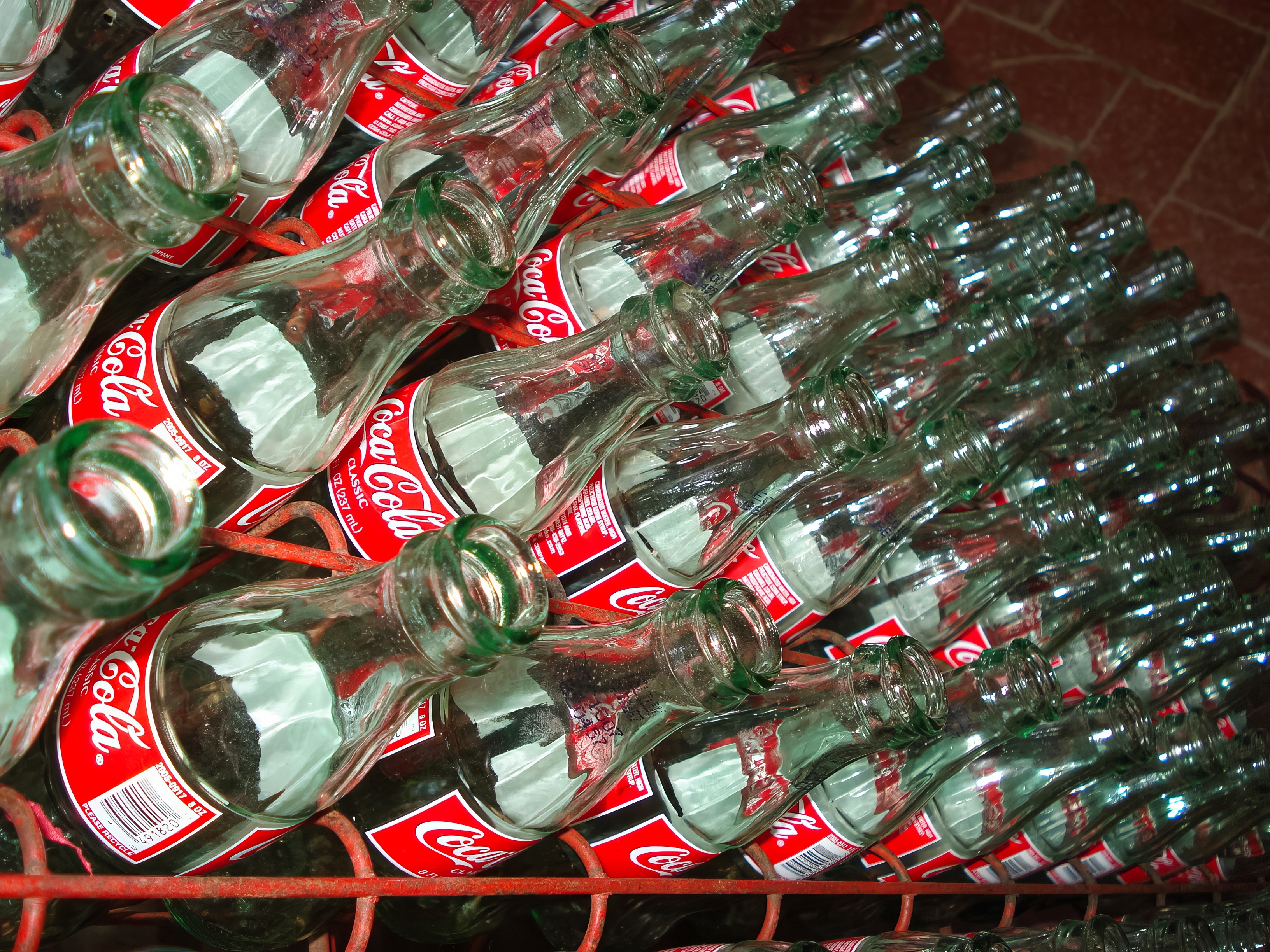 stack of vintage glass Coca-Cola bottles on a red rack 