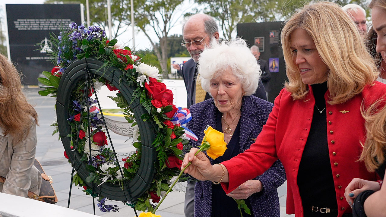 Jane Smith-Wolcott, center, widow of Challenger pilot Michael Smith and daughter Alison Smith Balch put flowers on a memorial during NASA's Day of Remembrance for the 40th Anniversary of the Challenger tragedy at the Kennedy Space Center Visitor Complex in Cape Canaveral, Fla., Thursday, Jan. 22, 2026. 