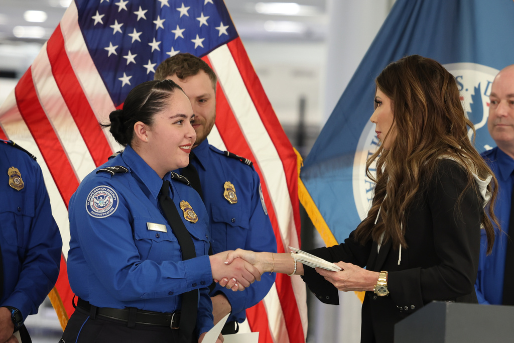 U.S. Homeland Security Secretary Kristi Noem, right, shakes hands with Transportation Security Administration Officer Monica Degro at a news conference at Harry Reid International Airport, Nov. 22, 2025, in Las Vegas.