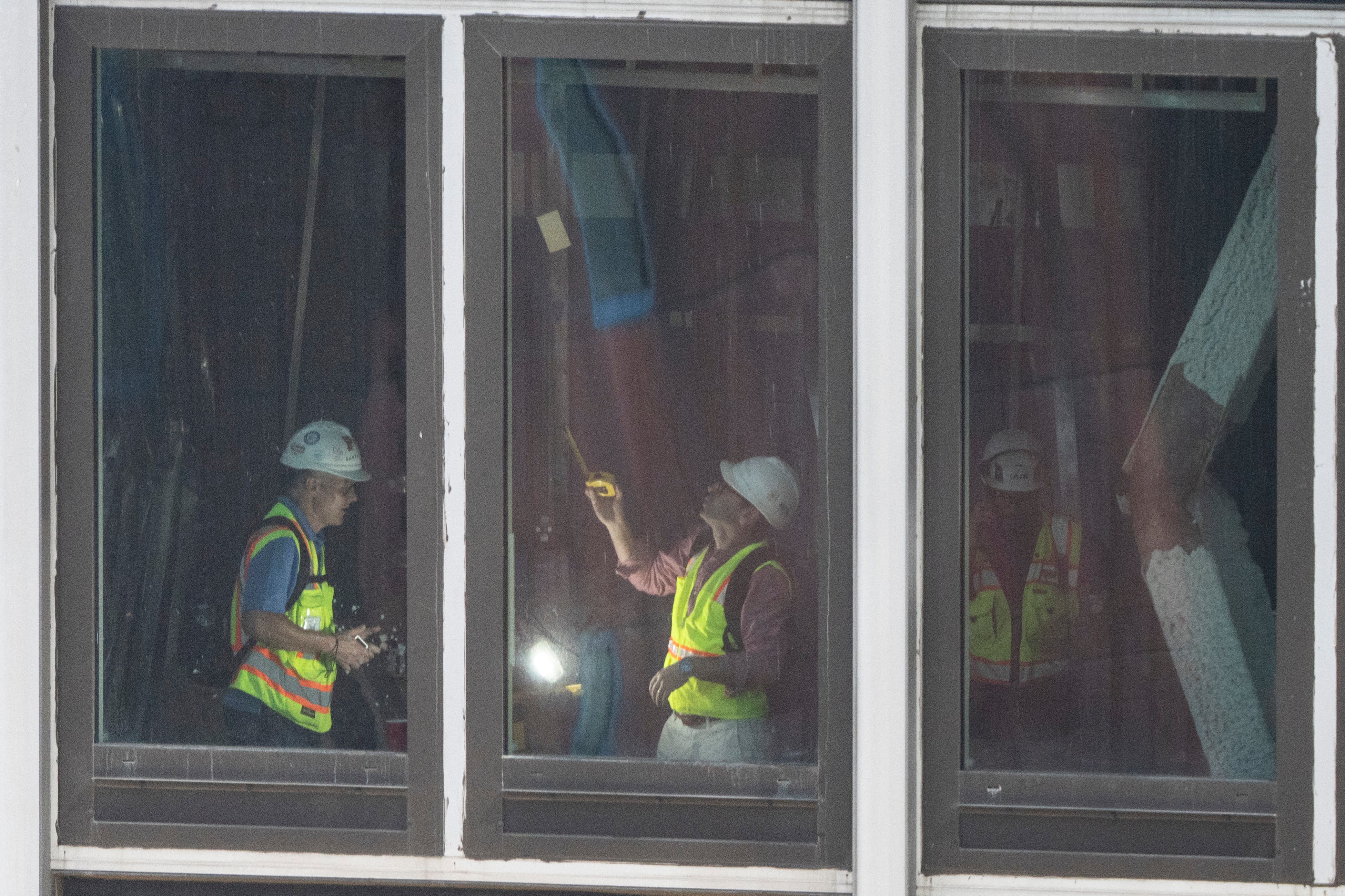People inspect a buckled support beam inside 235 East 42nd Street, Wednesday, July 8, 2026, in New York.