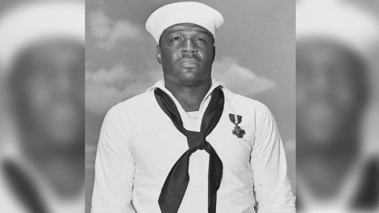 Doris Miller, Mess Attendant Second Class, US Navy, just after being presented with the Navy Cross by Admiral Chester W. Nimitz, on board USS Enterprise (CV-6) at Pearl Harbor, 27 May 1942. The medal was awarded for heroism on board USS West Virginia (BB-48) during the Pearl Harbor Attack, 7 December 1941.