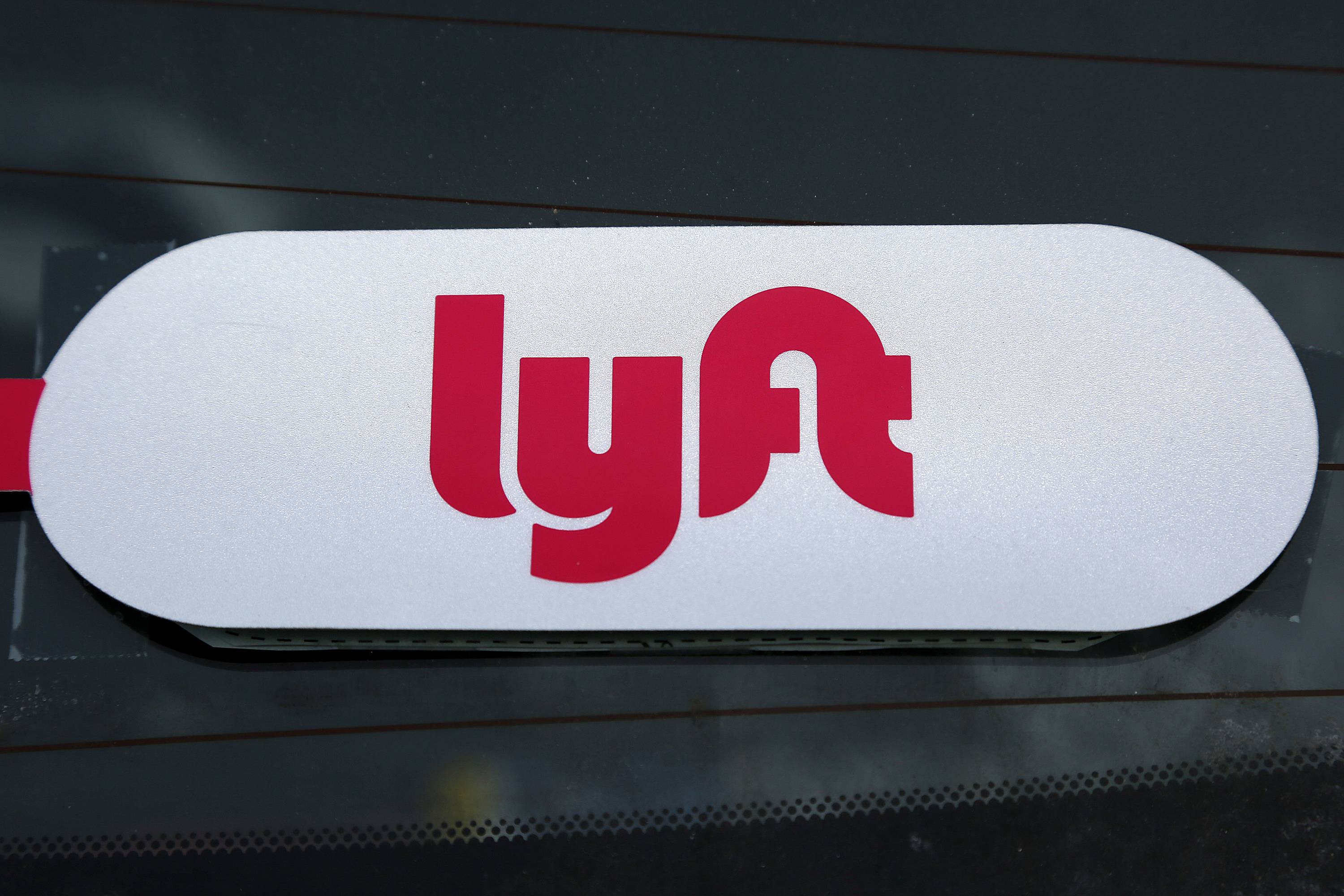 A Lyft logo is seen on a Lyft driver's car in Pittsburgh, Jan. 31, 2018. 